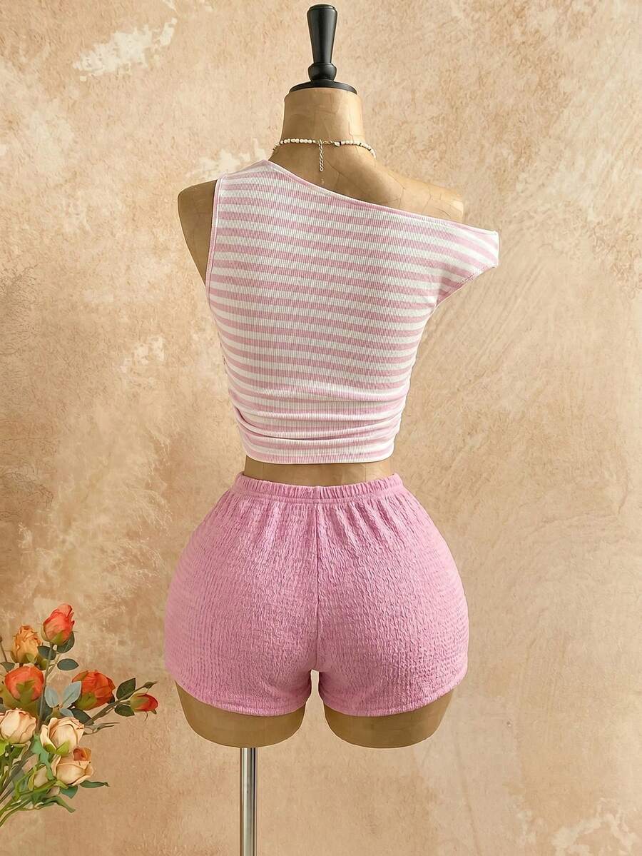 Women's black fuzzy knit two-piece set with an asymmetrical crop camisole top featuring ruched detail and cutout back, paired with matching mini shorts.