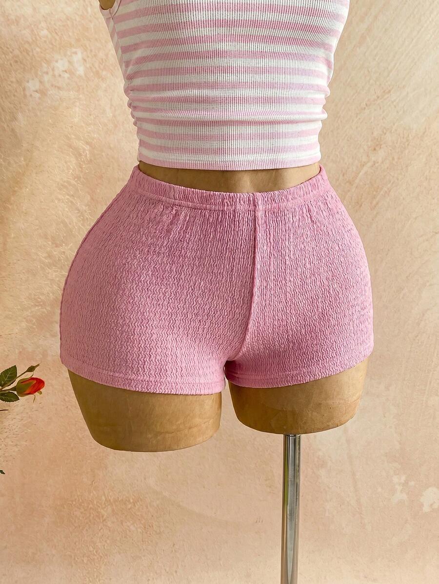 Women's black fuzzy knit two-piece set with an asymmetrical crop camisole top featuring ruched detail and cutout back, paired with matching mini shorts.