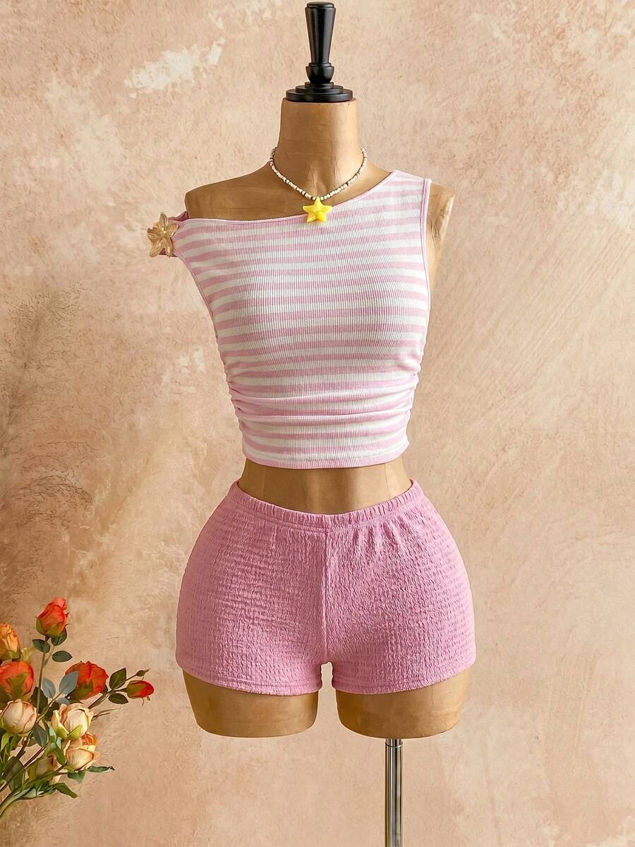 Women's black fuzzy knit two-piece set with an asymmetrical crop camisole top featuring ruched detail and cutout back, paired with matching mini shorts.