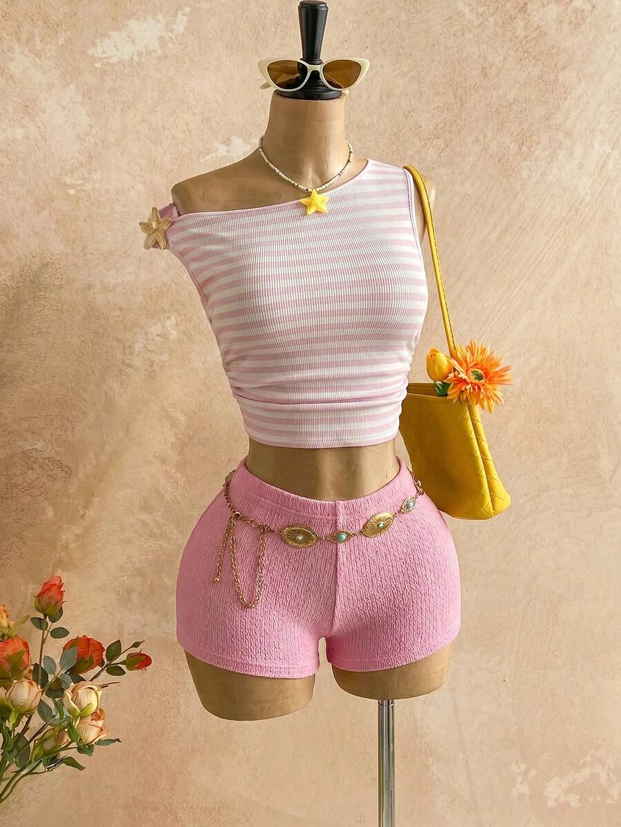 Women's black fuzzy knit two-piece set with an asymmetrical crop camisole top featuring ruched detail and cutout back, paired with matching mini shorts.
