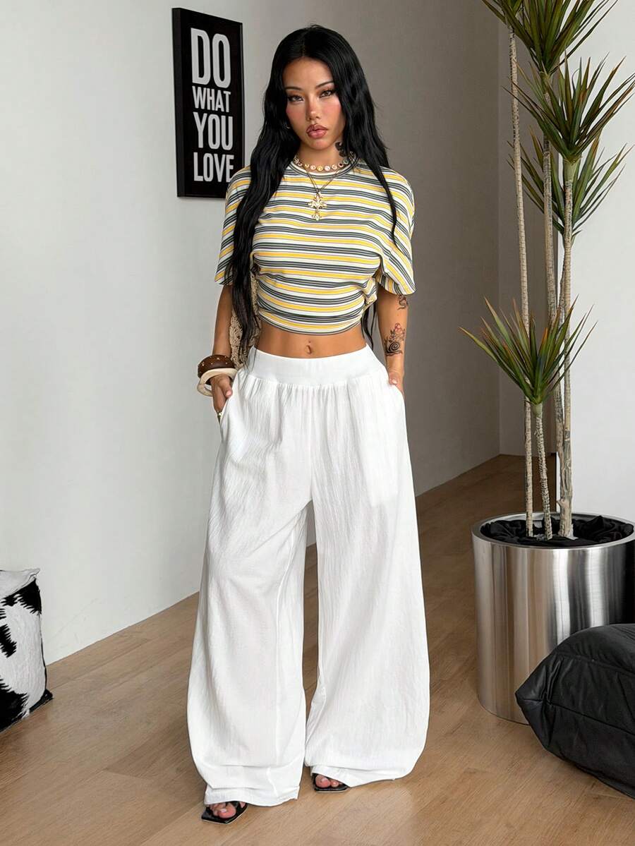 Women's white 100% cotton straight leg pants with an elastic drawstring waist and side pockets, styled in a loose casual fit.