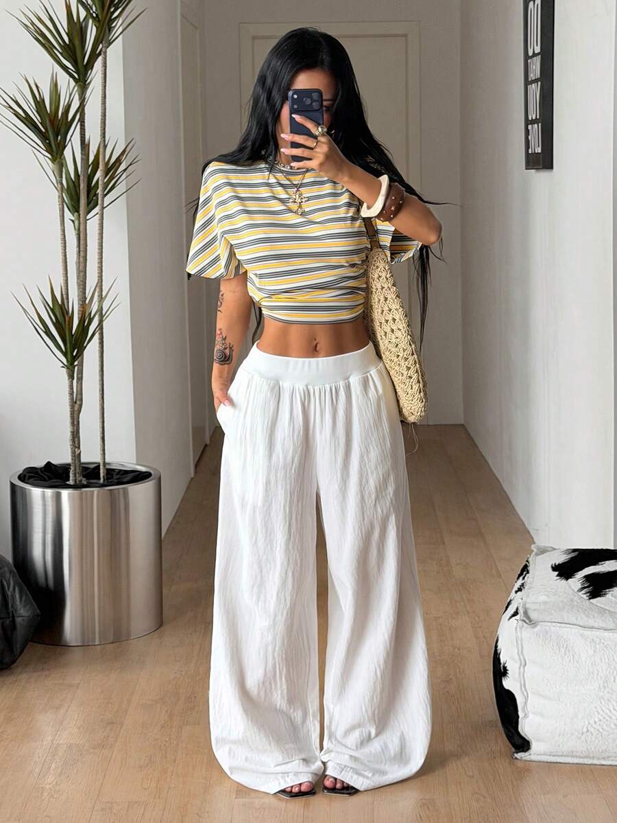 Women's white 100% cotton straight leg pants with an elastic drawstring waist and side pockets, styled in a loose casual fit.
