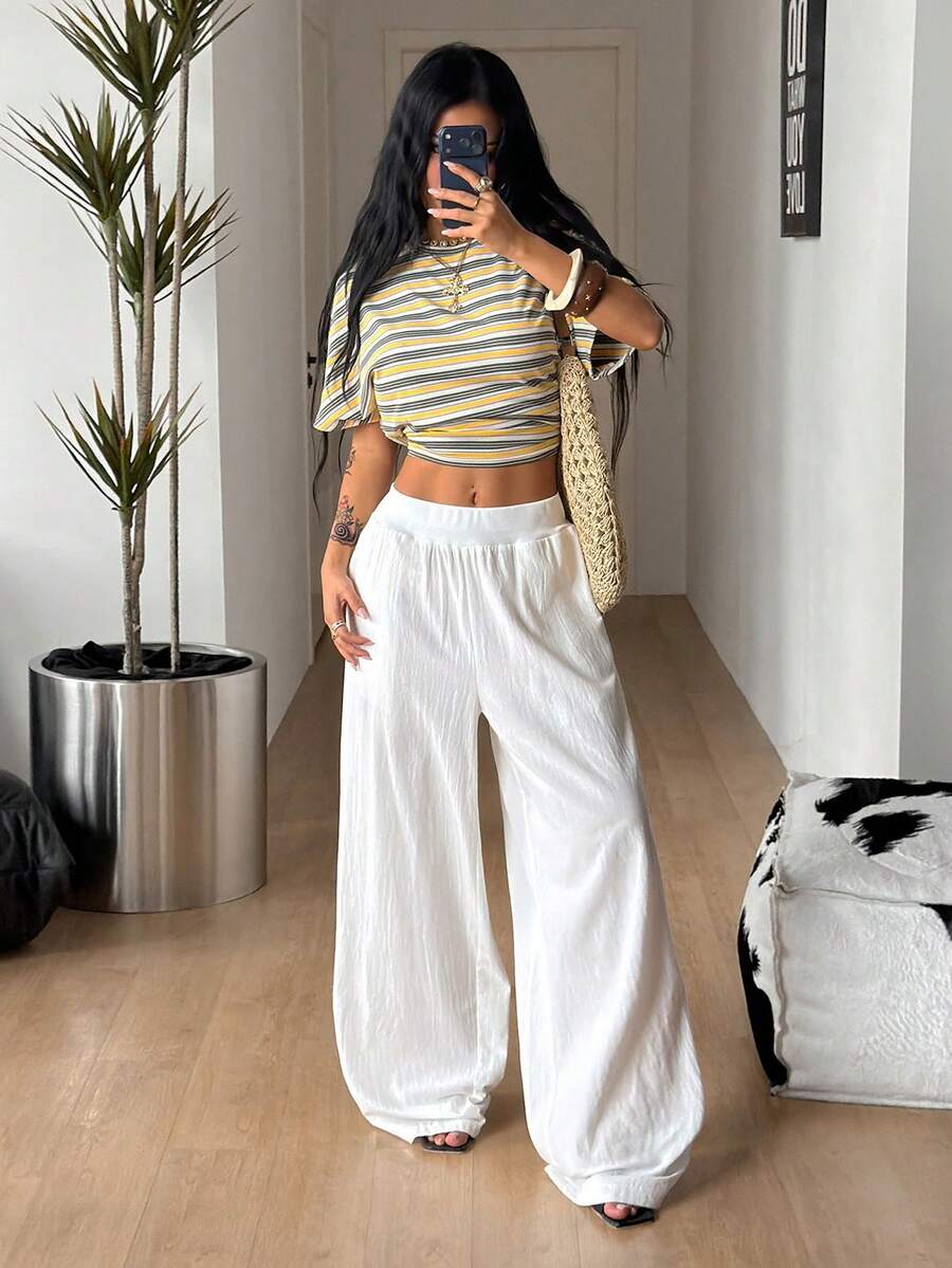 Women's white 100% cotton straight leg pants with an elastic drawstring waist and side pockets, styled in a loose casual fit.