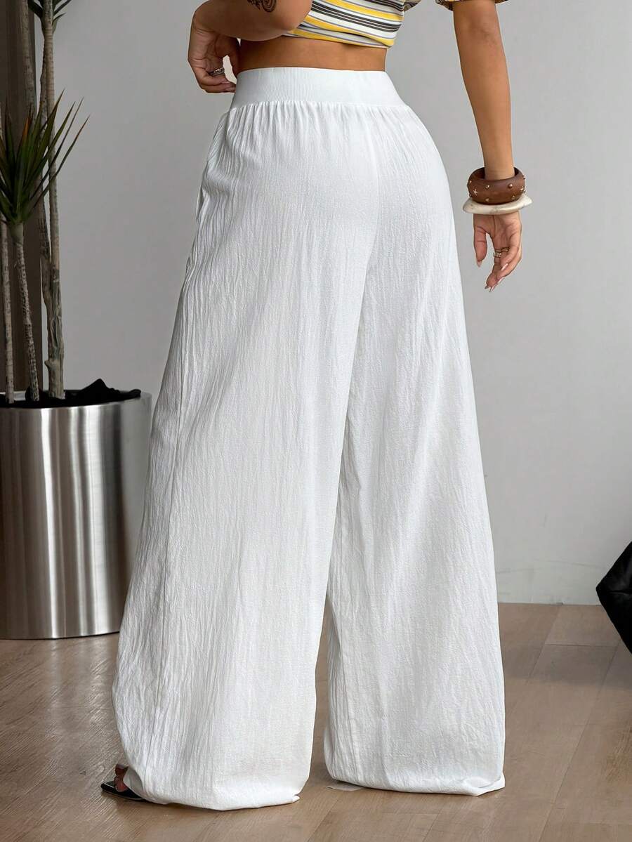Women's white 100% cotton straight leg pants with an elastic drawstring waist and side pockets, styled in a loose casual fit.