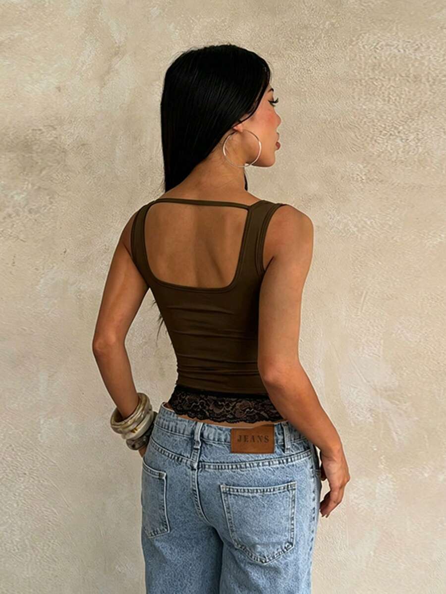 Women's white sleeveless crop tank top with contrast lace details, strap neckline, and graphic plant pattern in a slim fit.