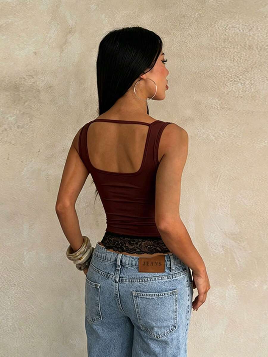 Women's white sleeveless crop tank top with contrast lace details, strap neckline, and graphic plant pattern in a slim fit.