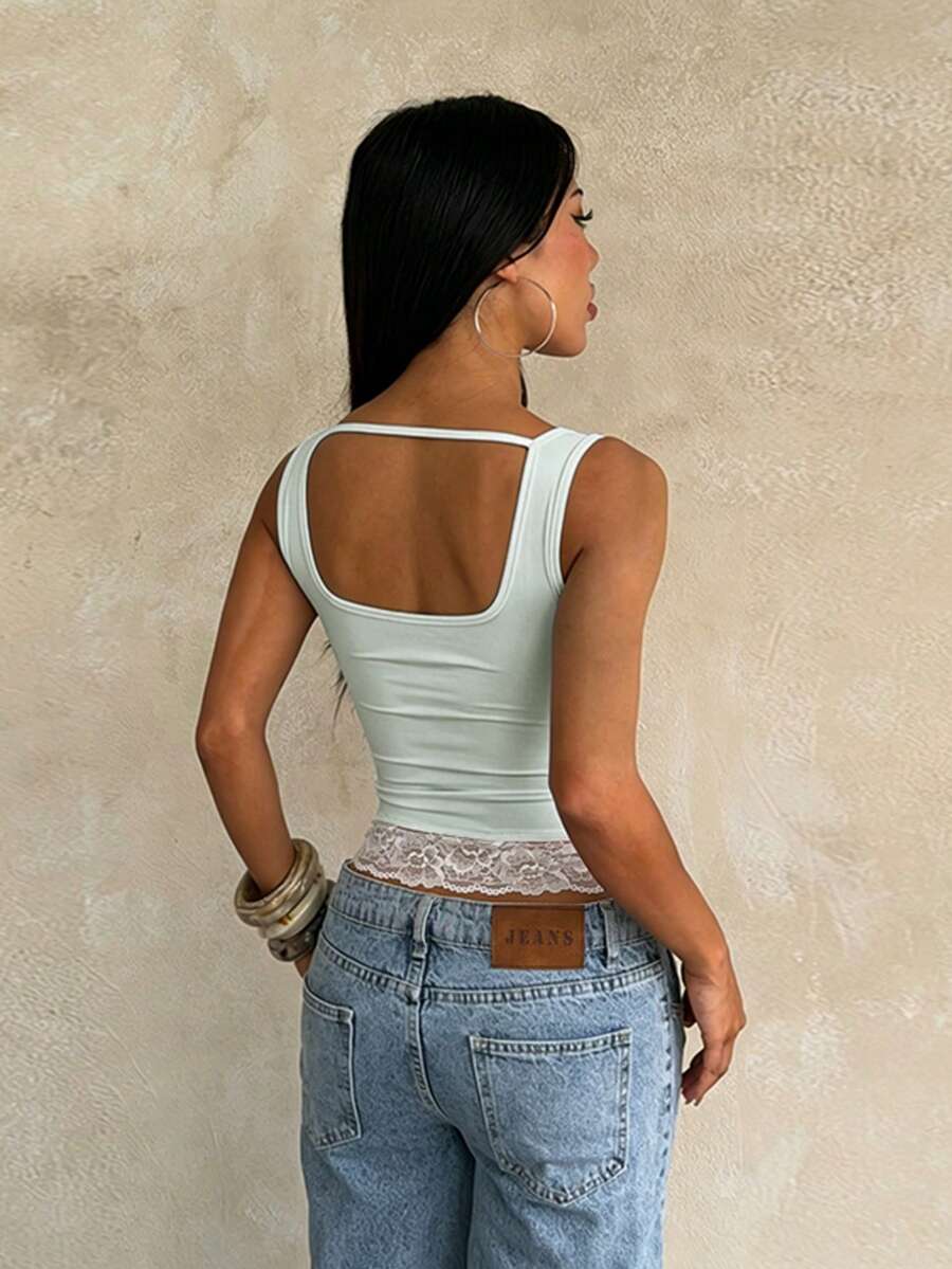 Women's white sleeveless crop tank top with contrast lace details, strap neckline, and graphic plant pattern in a slim fit.