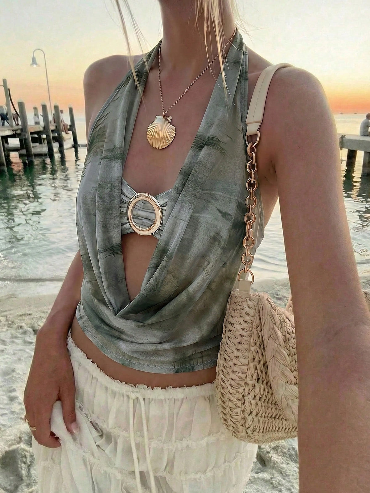 Brown and white polka dot semi-sheer halter camisole top with a plunging neckline, backless design, draped front, and metallic studded embellishments.