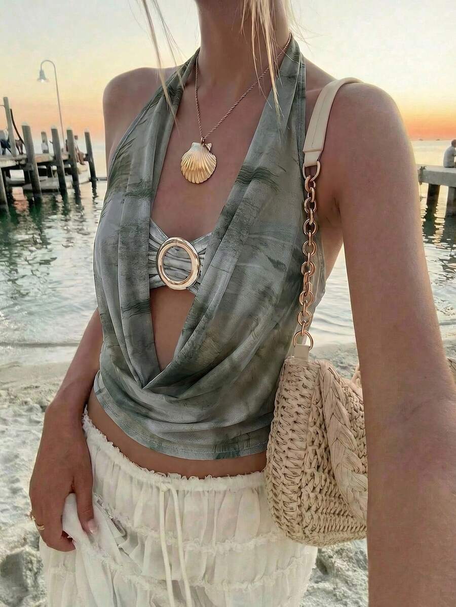 Brown and white polka dot semi-sheer halter camisole top with a plunging neckline, backless design, draped front, and metallic studded embellishments.