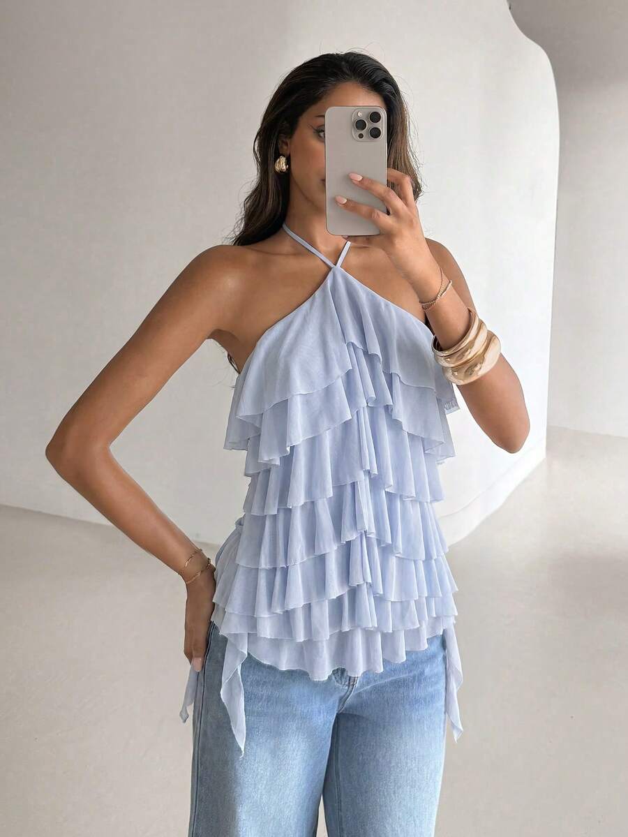 Women's sleeveless halter neck top featuring tiered ruffle layers, a backless cut, and an asymmetrical hem.