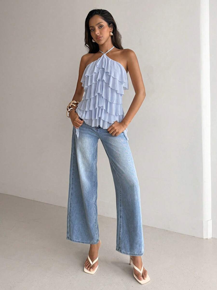 Women's sleeveless halter neck top featuring tiered ruffle layers, a backless cut, and an asymmetrical hem.