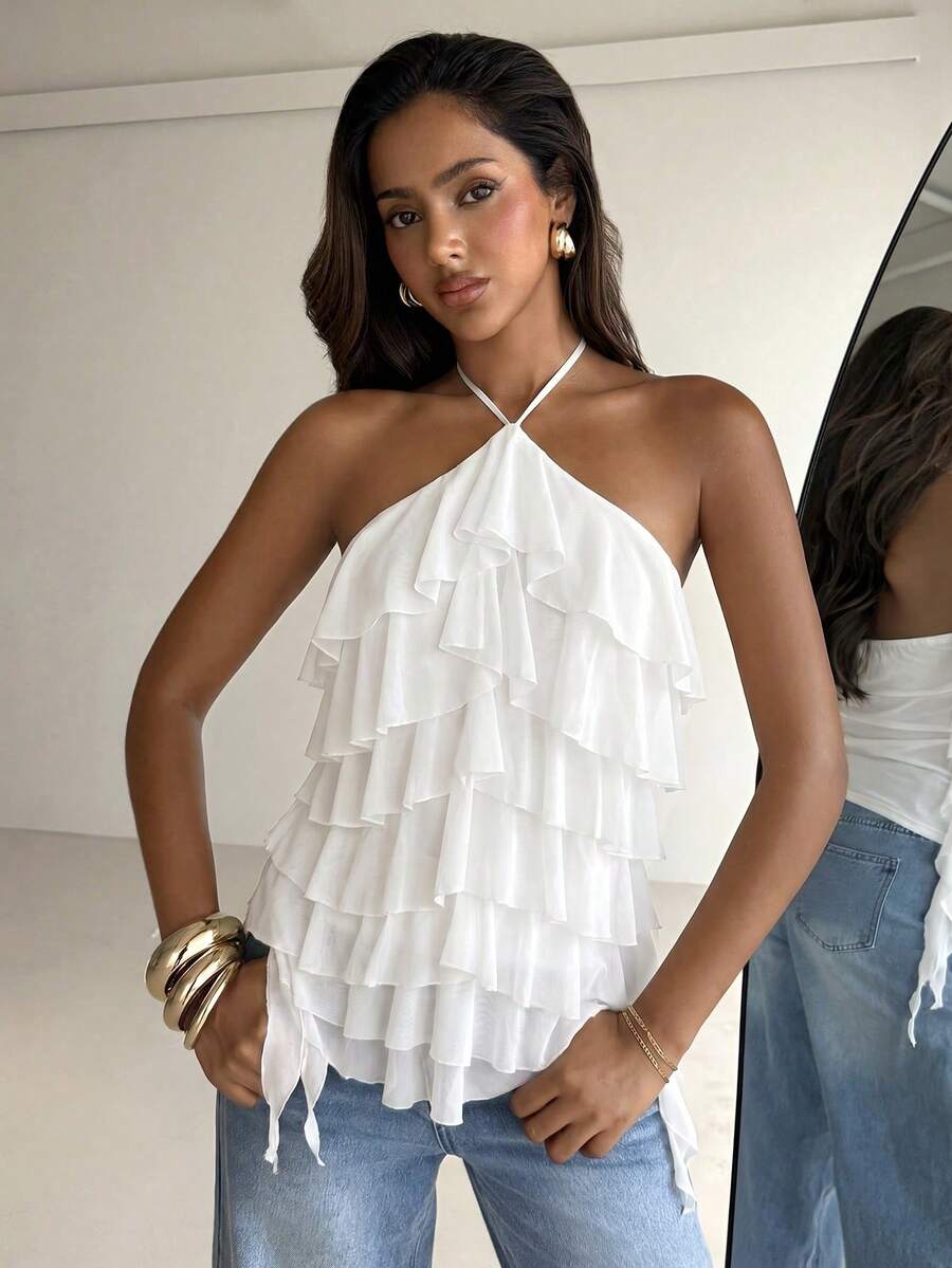 Women's sleeveless halter neck top featuring tiered ruffle layers, a backless cut, and an asymmetrical hem.