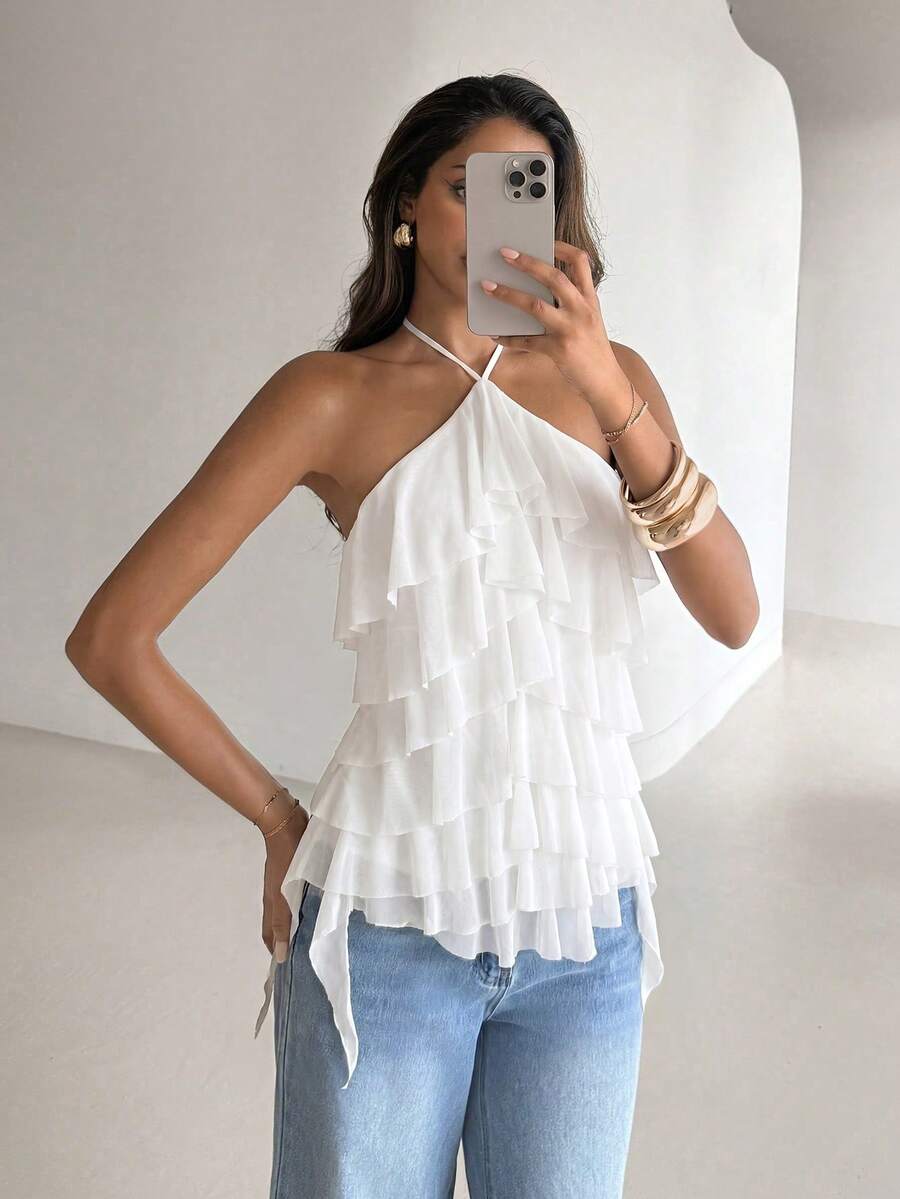 Women's sleeveless halter neck top featuring tiered ruffle layers, a backless cut, and an asymmetrical hem.