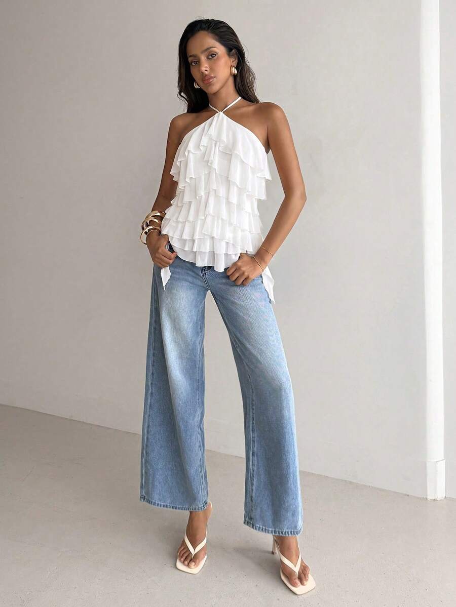 Women's sleeveless halter neck top featuring tiered ruffle layers, a backless cut, and an asymmetrical hem.