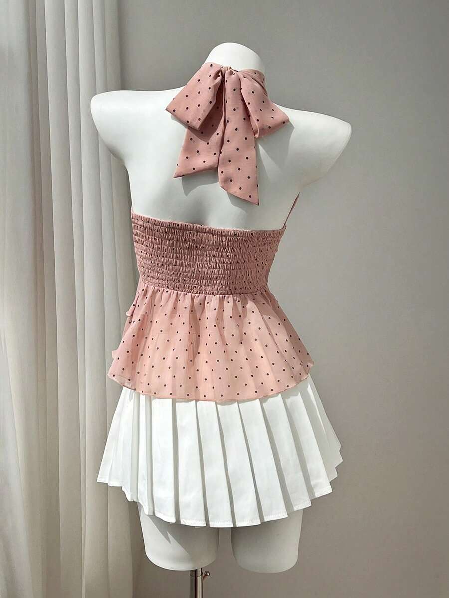 Women's white sleeveless halter neck top featuring pleated fabric, backless tie strap design, and a flared layered ruffle hem.