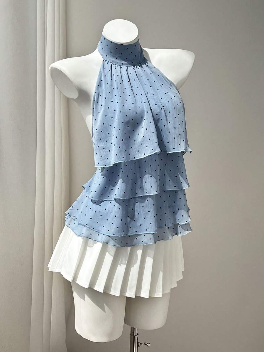Women's white sleeveless halter neck top featuring pleated fabric, backless tie strap design, and a flared layered ruffle hem.