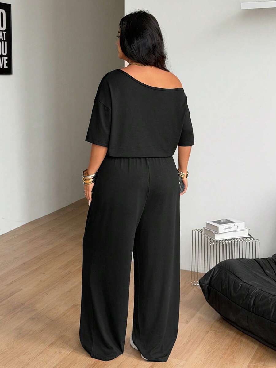 Plus size women's wide leg jumpsuit in dark grey featuring an asymmetrical neckline, short batwing sleeves, and a drawstring high waist with side pockets.