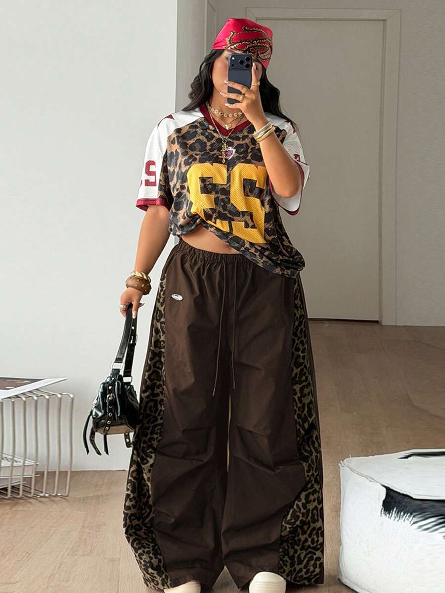 Women's high waist wide leg pants in black featuring leopard print patchwork details and an elastic drawstring waistband.