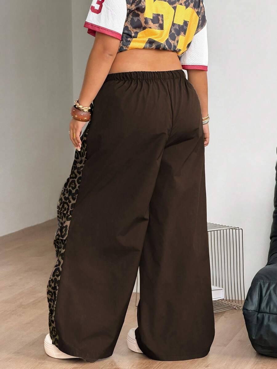 Women's high waist wide leg pants in black featuring leopard print patchwork details and an elastic drawstring waistband.