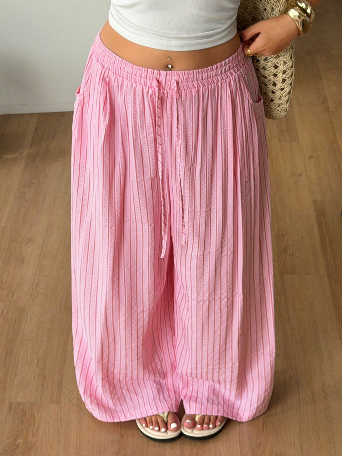 Plus size women's striped loose straight leg cropped pants with pleated detailing and side pockets