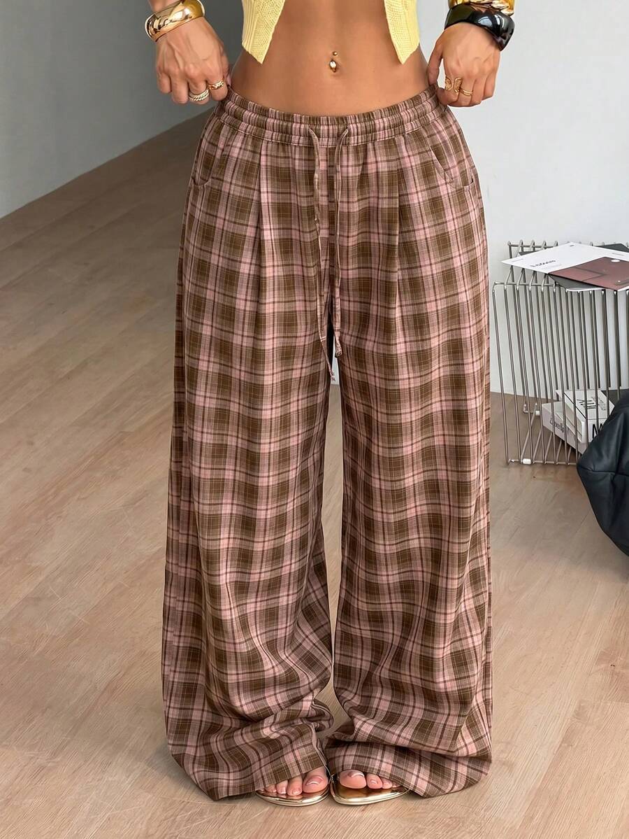 Women's loose fit brown and tan plaid wide leg pants featuring an elastic drawstring waist and side pockets.