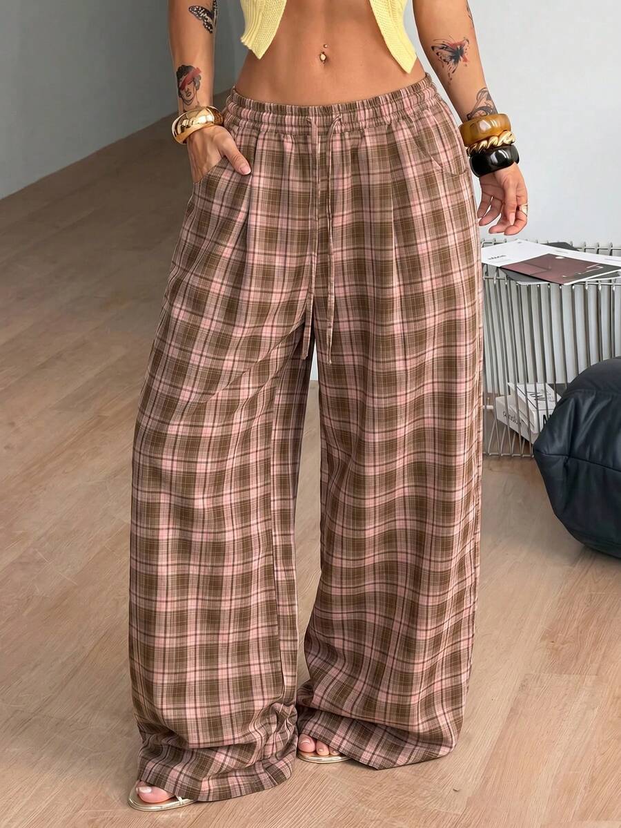 Women's loose fit brown and tan plaid wide leg pants featuring an elastic drawstring waist and side pockets.
