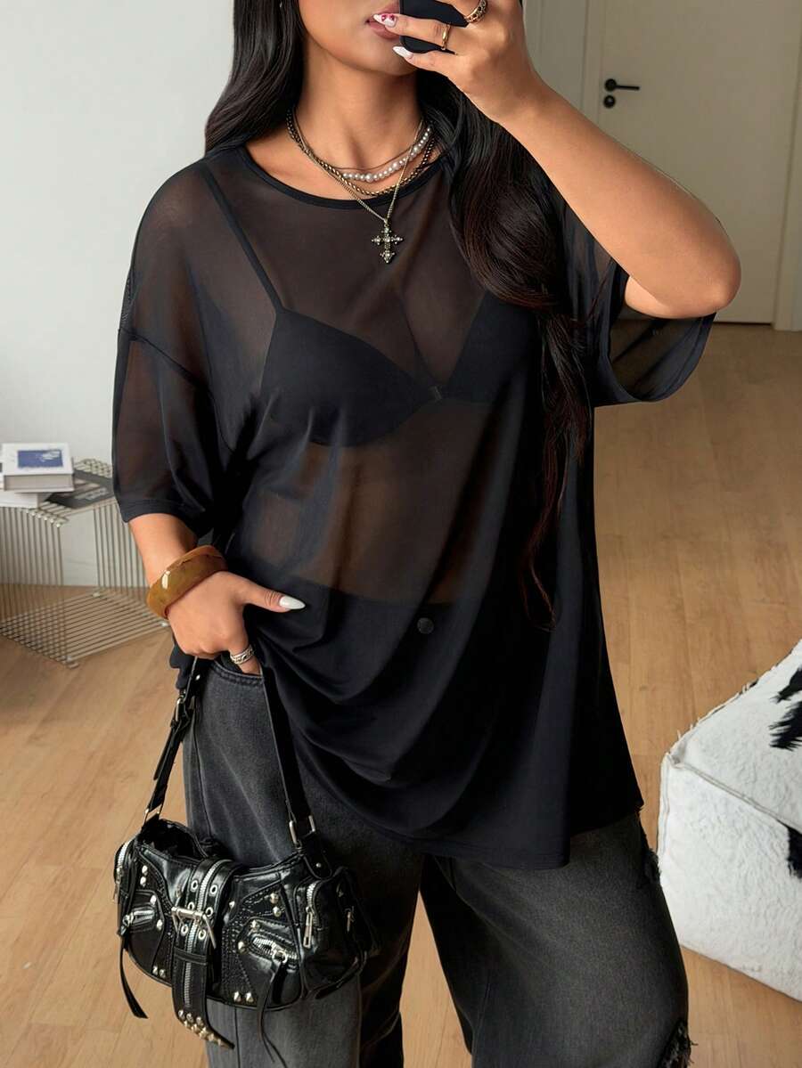 Women's plus size black sheer mesh top featuring a loose fit, round neck, and drop shoulder half sleeves.