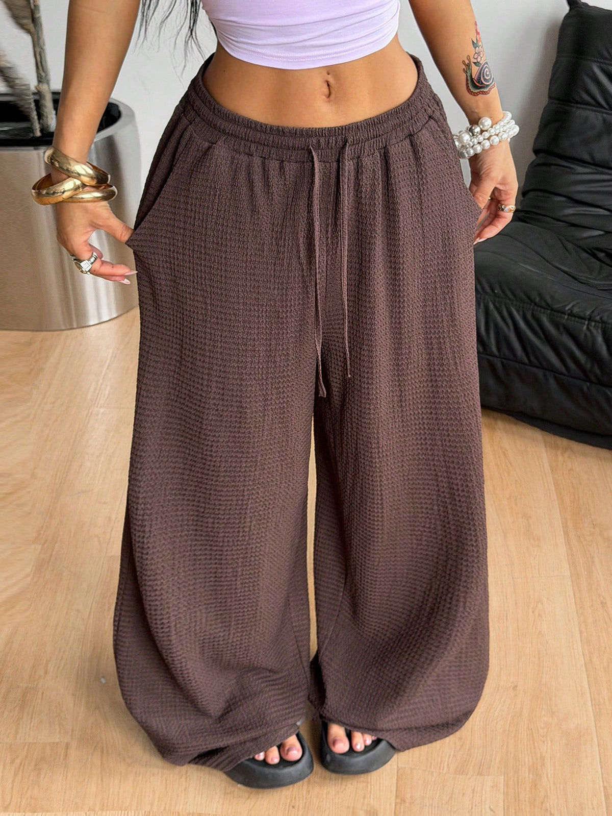 Women's loose straight leg cotton pants featuring a high waist with an adjustable drawstring knot and functional side pockets.