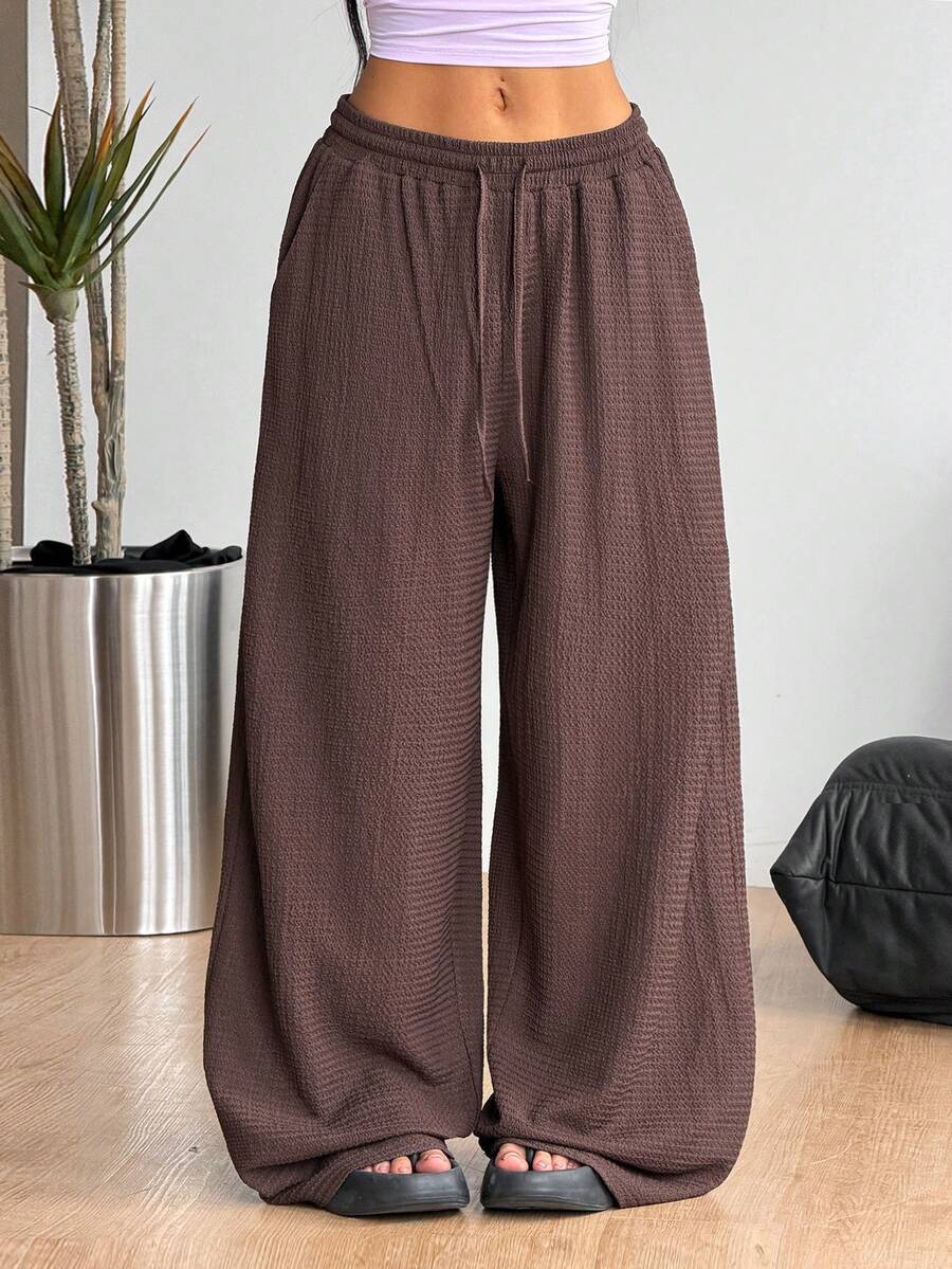 Women's loose fit straight leg lounge pants in textured knit fabric featuring an elastic drawstring waist and side pockets