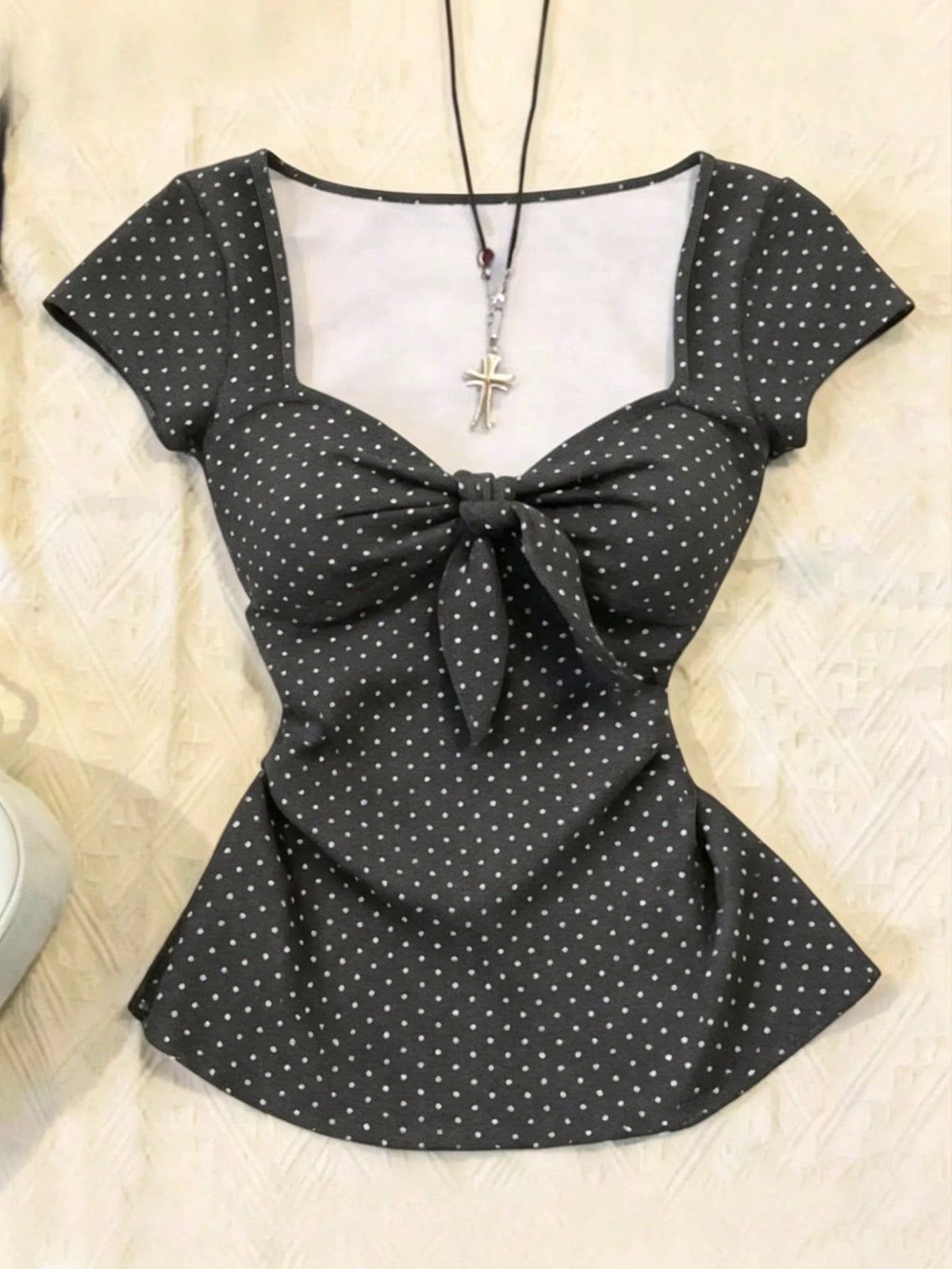 Women's polka dot short sleeve raglan t-shirt with a twist front detail and contrast collar.