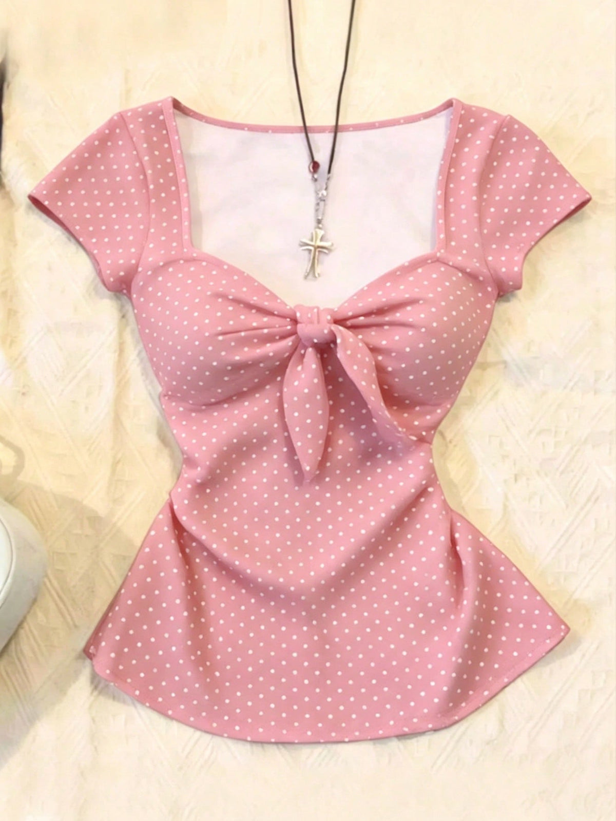 Women's polka dot short sleeve raglan t-shirt with a twist front detail and contrast collar.