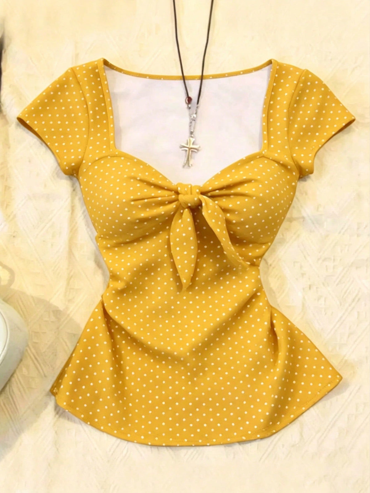 Women's polka dot short sleeve raglan t-shirt with a twist front detail and contrast collar.