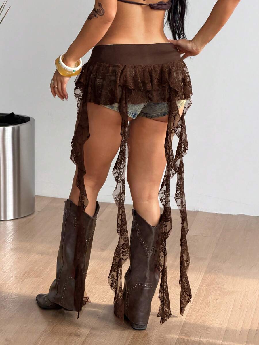 Women's black semi-sheer lace asymmetrical skirt with fringe details, contrast lace, low waist, and ruffle hem for beach, party, concert, or festival outfits.