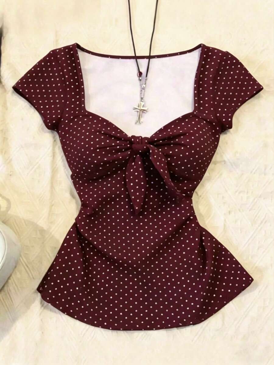 Women's polka dot short sleeve raglan t-shirt with a twist front detail and contrast collar.
