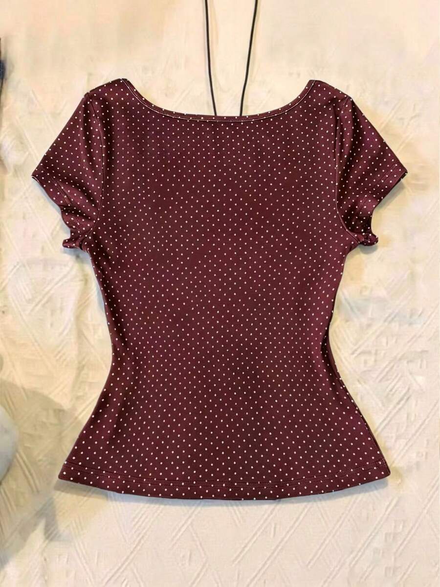 Women's polka dot short sleeve raglan t-shirt with a twist front detail and contrast collar.
