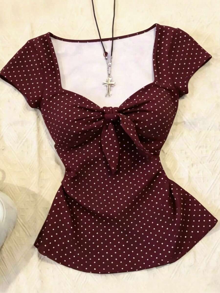 Women's polka dot short sleeve raglan t-shirt with a twist front detail and contrast collar.