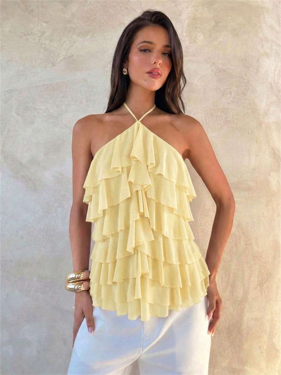 Women's sleeveless halter neck top featuring tiered ruffle layers, a backless cut, and an asymmetrical hem.