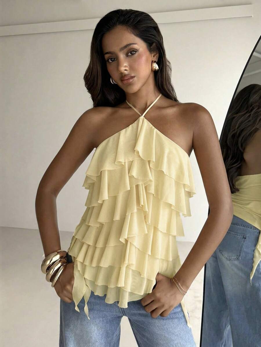 Women's sleeveless halter neck top featuring tiered ruffle layers, a backless cut, and an asymmetrical hem.