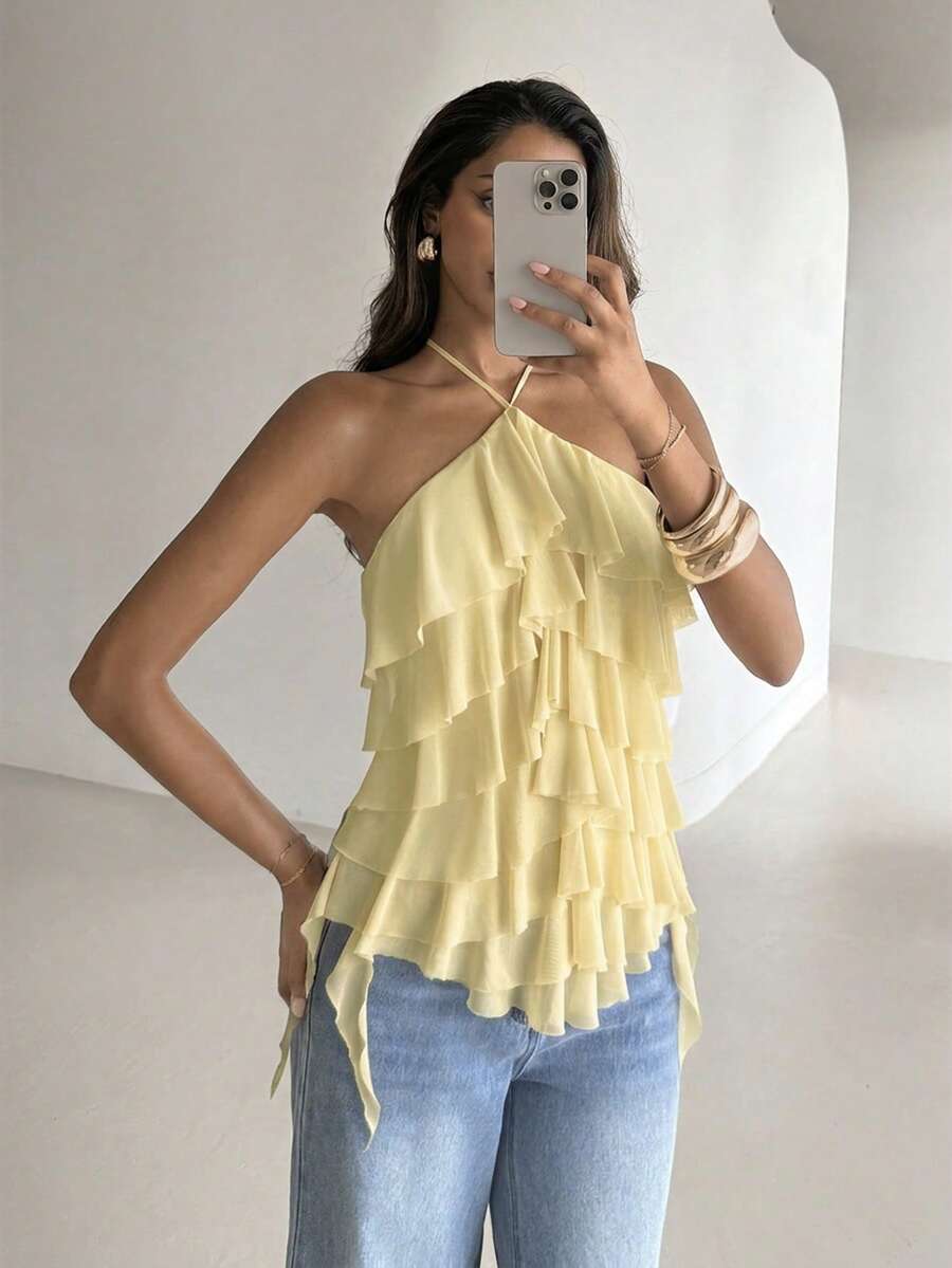 Women's sleeveless halter neck top featuring tiered ruffle layers, a backless cut, and an asymmetrical hem.