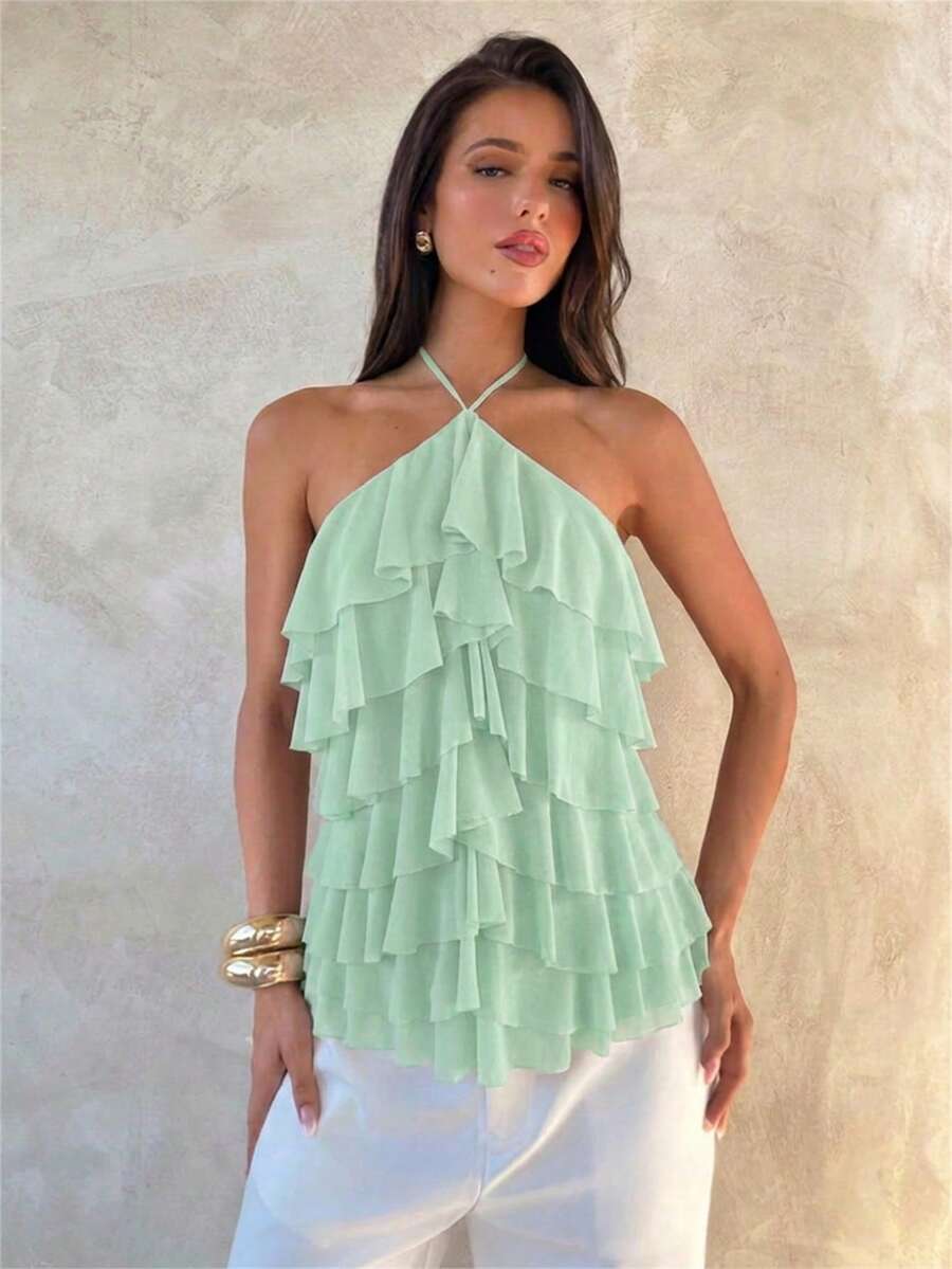Women's sleeveless halter neck top featuring tiered ruffle layers, a backless cut, and an asymmetrical hem.