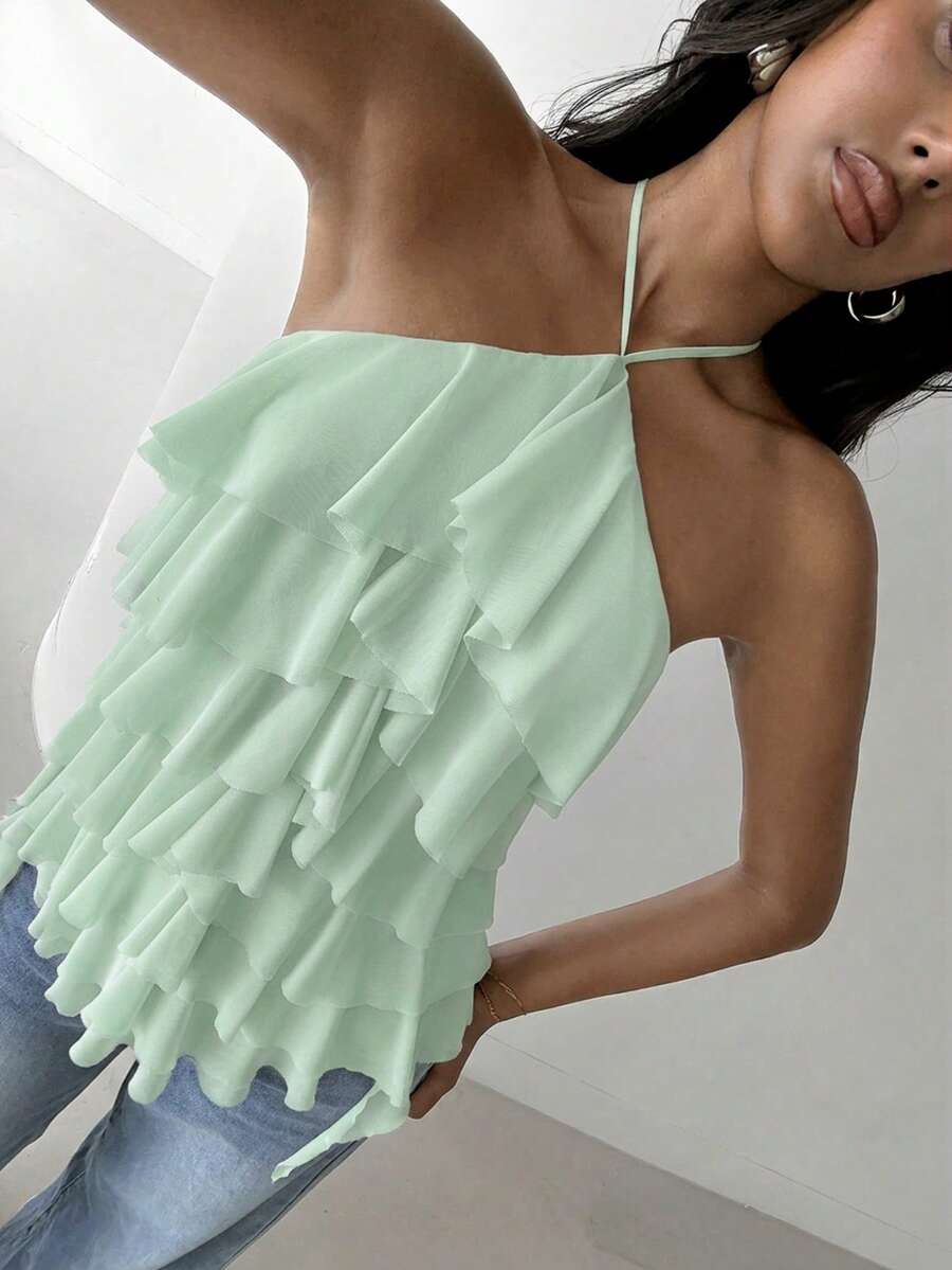Women's sleeveless halter neck top featuring tiered ruffle layers, a backless cut, and an asymmetrical hem.