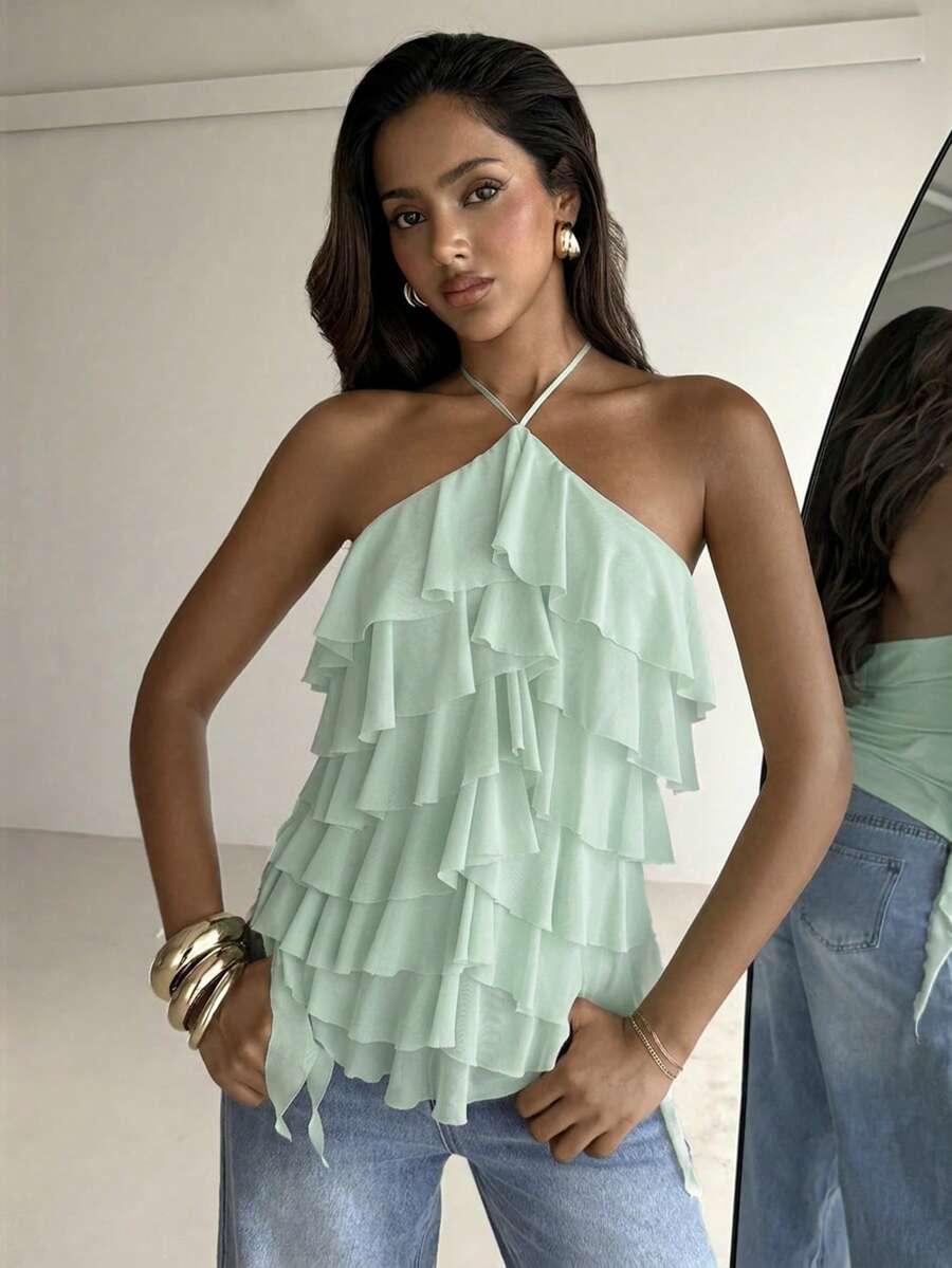 Women's sleeveless halter neck top featuring tiered ruffle layers, a backless cut, and an asymmetrical hem.