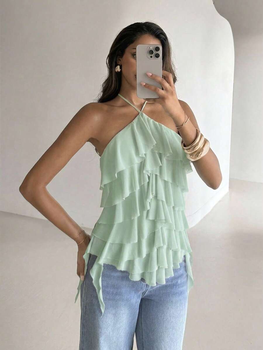Women's sleeveless halter neck top featuring tiered ruffle layers, a backless cut, and an asymmetrical hem.