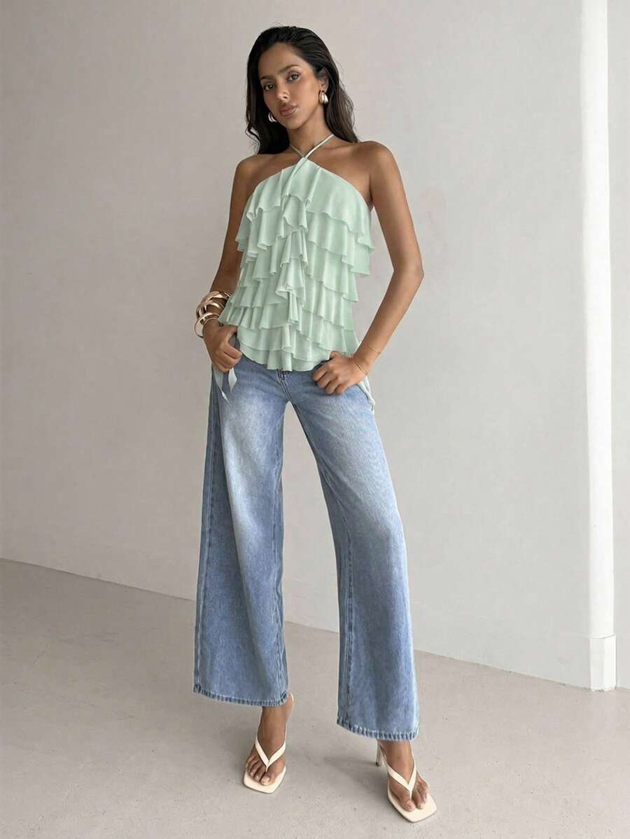 Women's sleeveless halter neck top featuring tiered ruffle layers, a backless cut, and an asymmetrical hem.
