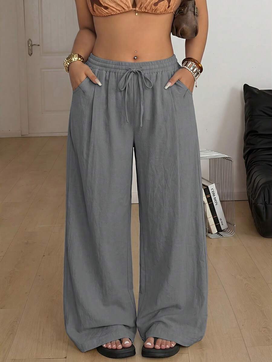 Women's loose straight leg cotton pants featuring a high waist with an adjustable drawstring knot and functional side pockets.