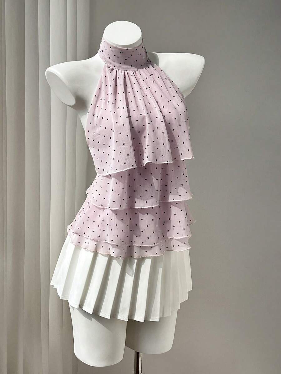 Women's white sleeveless halter neck top featuring pleated fabric, backless tie strap design, and a flared layered ruffle hem.