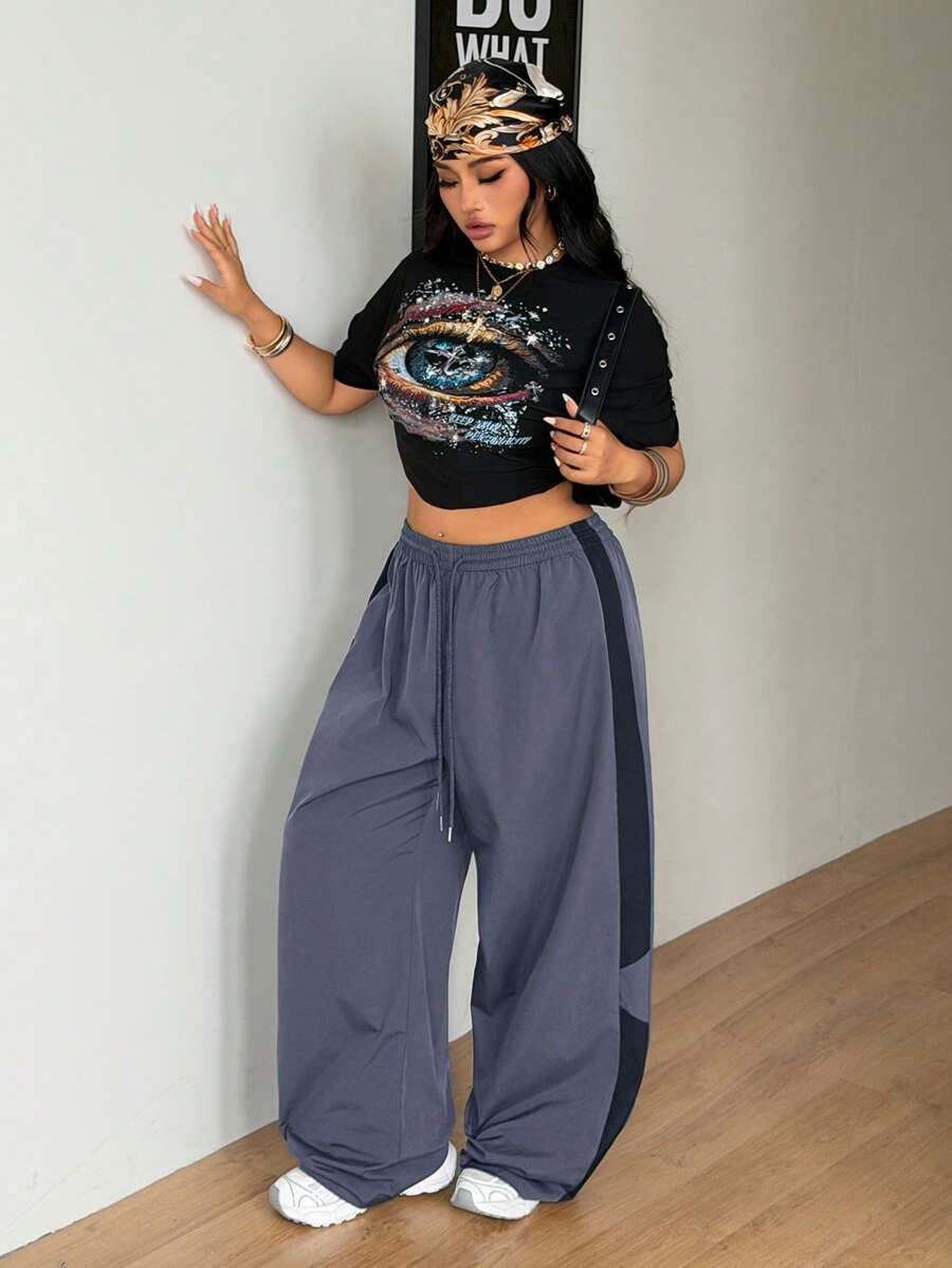 Women's plus size loose straight leg pants featuring a black and white color block design with side stripes and an elastic drawstring waist.
