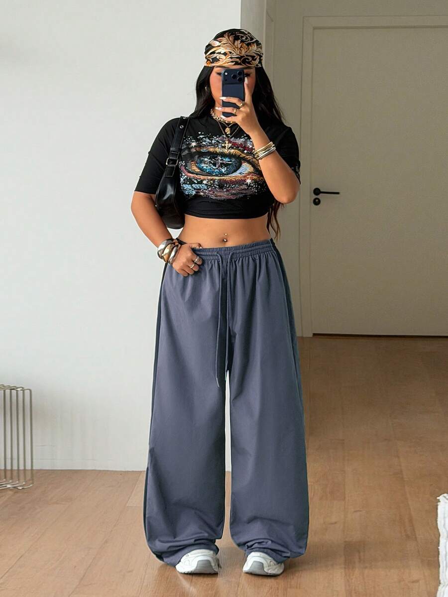 Women's plus size loose straight leg pants featuring a black and white color block design with side stripes and an elastic drawstring waist.