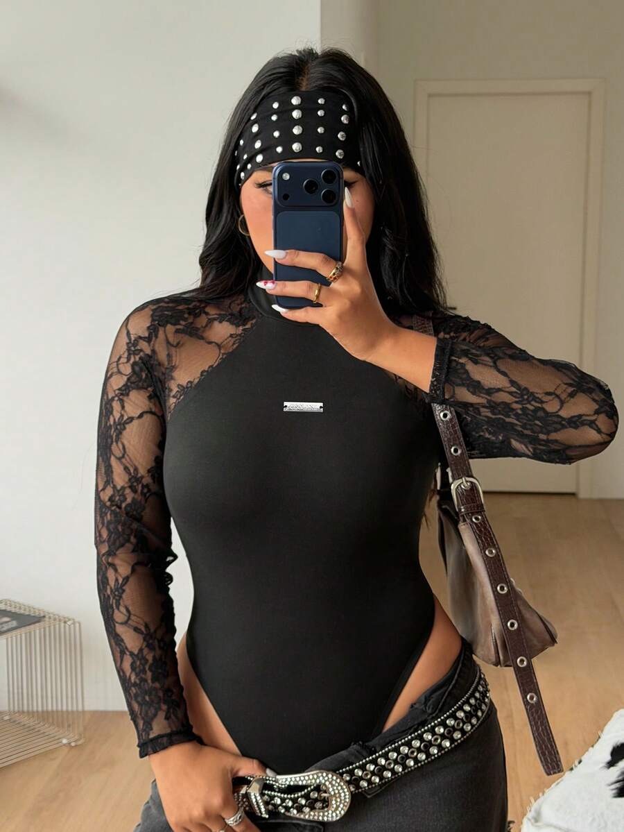 Women's black long sleeve bodysuit with sheer contrast lace raglan sleeves and stand collar.