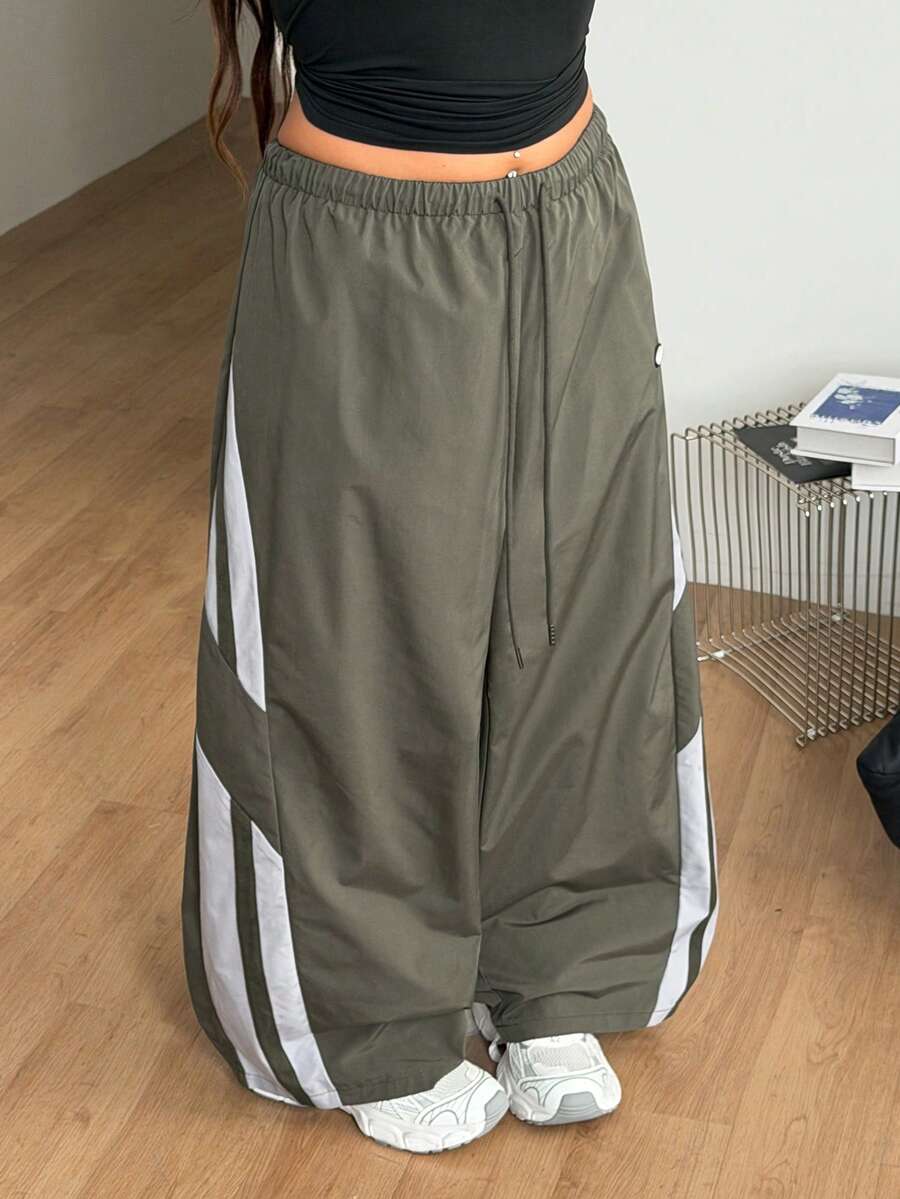 Women's plus size loose straight leg pants featuring a black and white color block design with side stripes and an elastic drawstring waist.